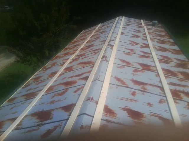Rusted metal roof panels with new wood purlins before replacement — Storm Damage Roof Repair in East Freedom by Roofing Brothers