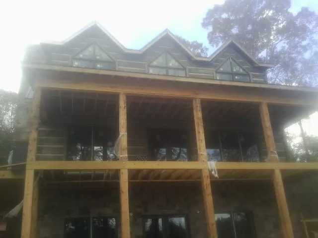 Dormers and porch framing on a large log home under construction — Roof Coating work by our crew in East Freedom