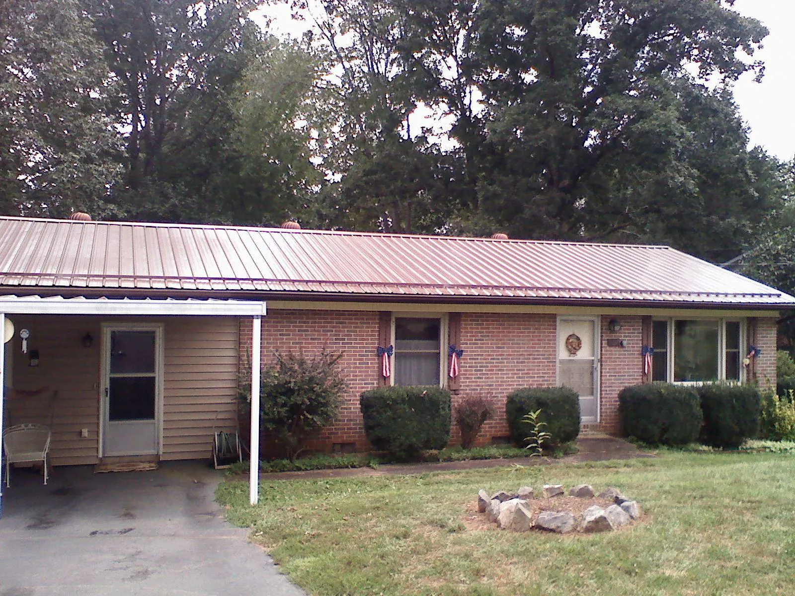 Bronze metal roof and carport on a brick ranch home — Roof Repair work by our crew in East Freedom